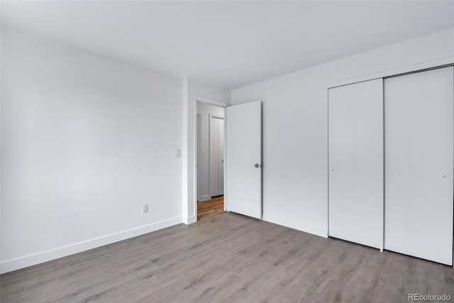 unfurnished bedroom with a closet and light hardwood / wood-style flooring