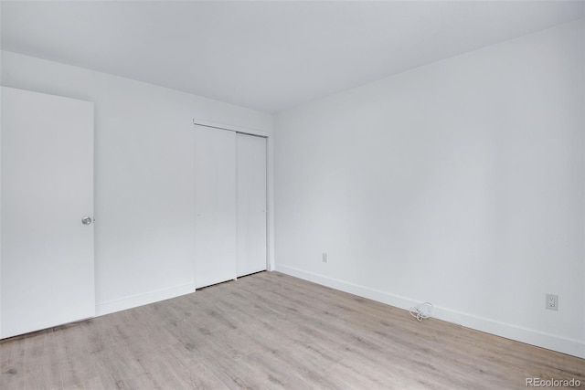 unfurnished bedroom featuring a closet and light wood-type flooring