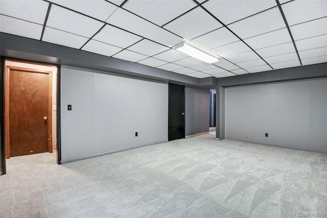 basement featuring light colored carpet and a drop ceiling