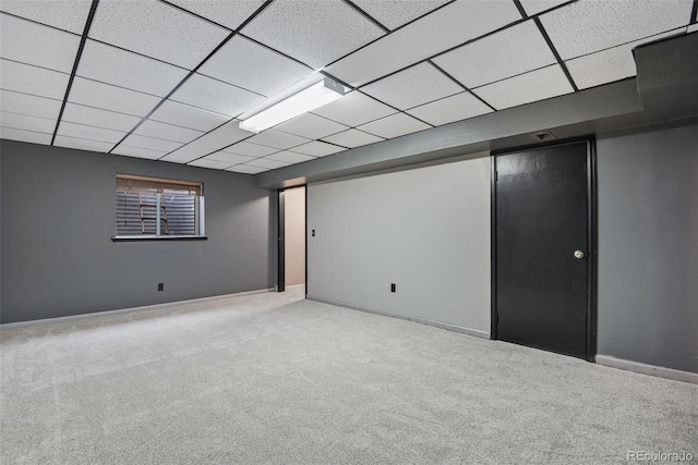 basement with a drop ceiling and light colored carpet