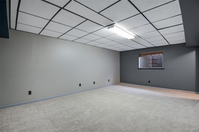 basement featuring light colored carpet and a drop ceiling