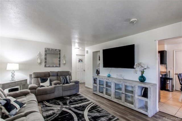 living room with a textured ceiling and wood finished floors