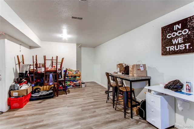 rec room with visible vents, a textured ceiling, and wood finished floors