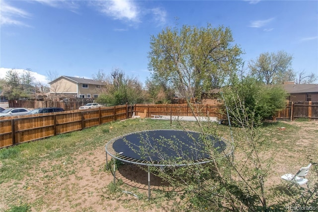 view of yard with a fenced backyard and a trampoline