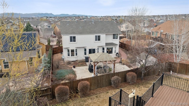 rear view of house featuring a fenced backyard, a residential view, stucco siding, and a shingled roof