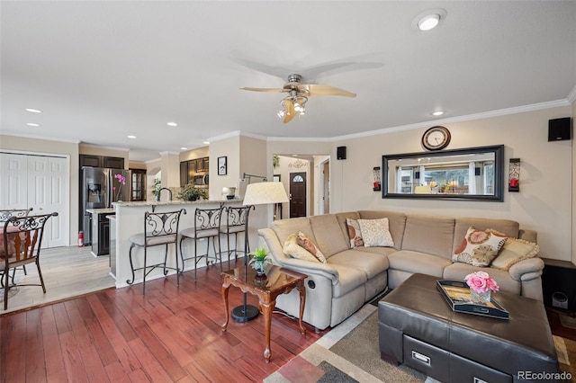 living room featuring recessed lighting, wood finished floors, ceiling fan, and ornamental molding