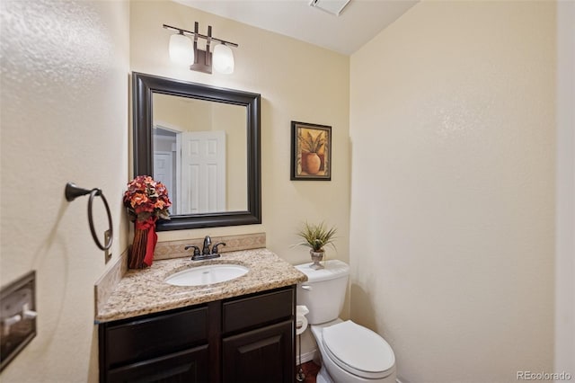 bathroom featuring toilet and vanity