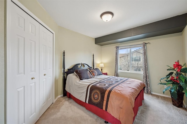 carpeted bedroom with baseboards and a closet