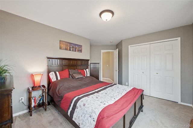 bedroom with light colored carpet, a closet, and baseboards