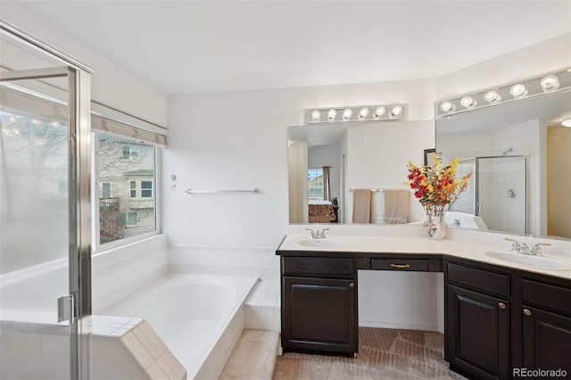 ensuite bathroom with ensuite bathroom, a sink, a stall shower, and a garden tub