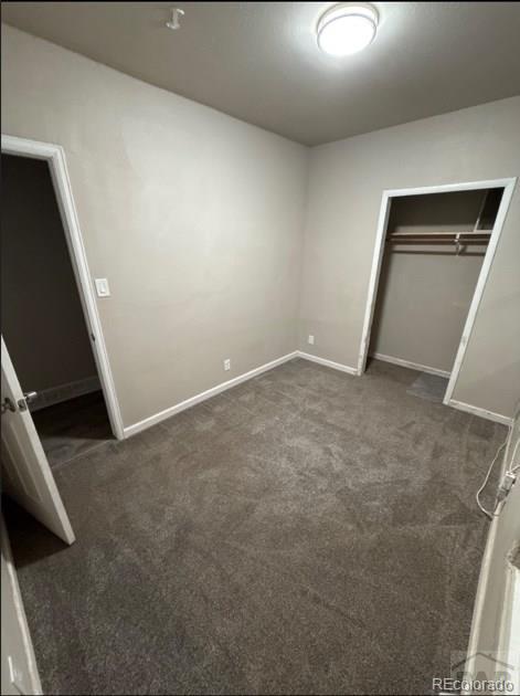 1317 Bragdon Ave, Pueblo, CO 81004 - unfurnished bedroom with dark colored carpet, baseboards, and a closet