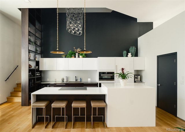 kitchen with sink, light wood-type flooring, and white cabinetry