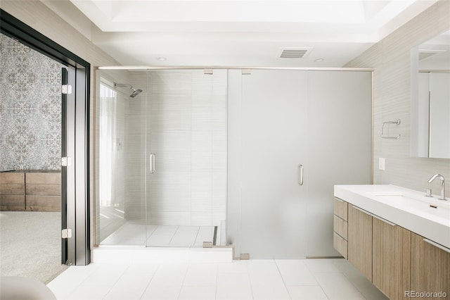 bathroom featuring tile flooring, a shower with shower door, and vanity