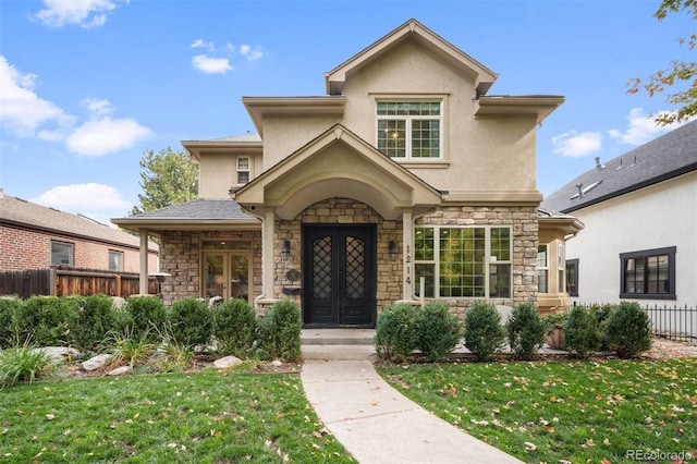 view of front of property featuring french doors, stone siding, fence, and stucco siding