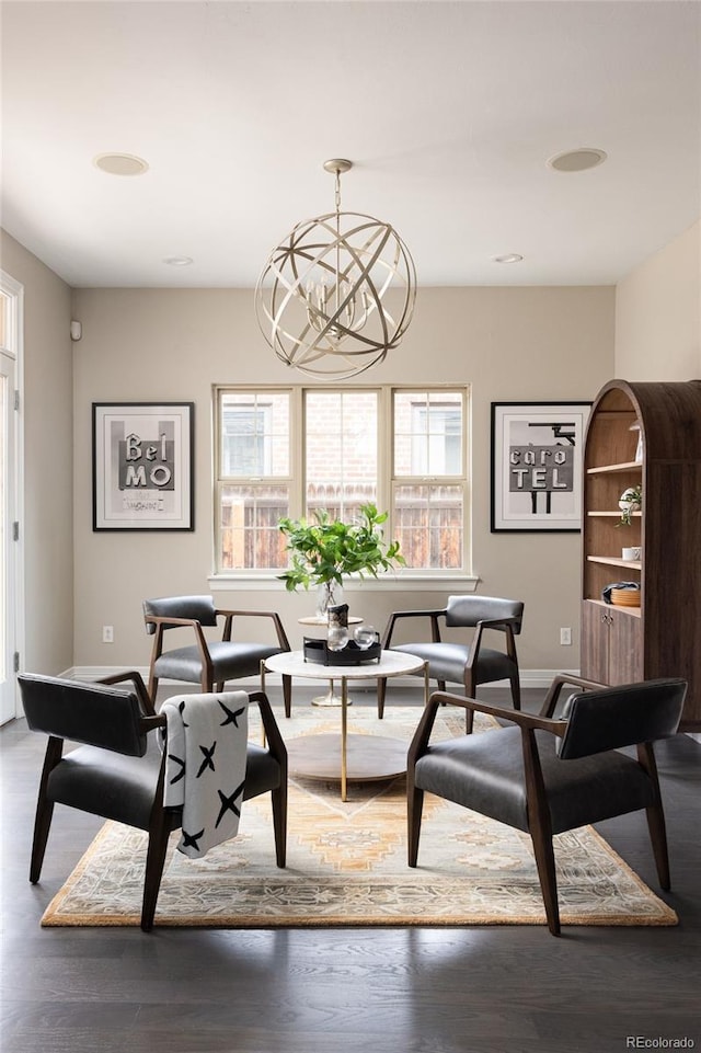 dining room featuring a notable chandelier, wood finished floors, and baseboards