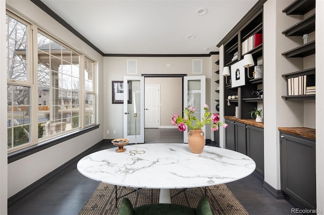 dining room with plenty of natural light, dark wood-style floors, and ornamental molding