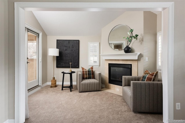 sitting room featuring a tiled fireplace, vaulted ceiling, carpet, and baseboards