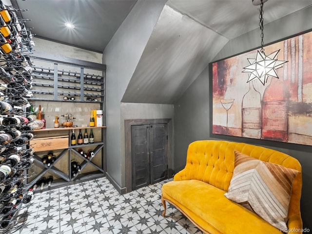 wine area featuring tile patterned floors and lofted ceiling