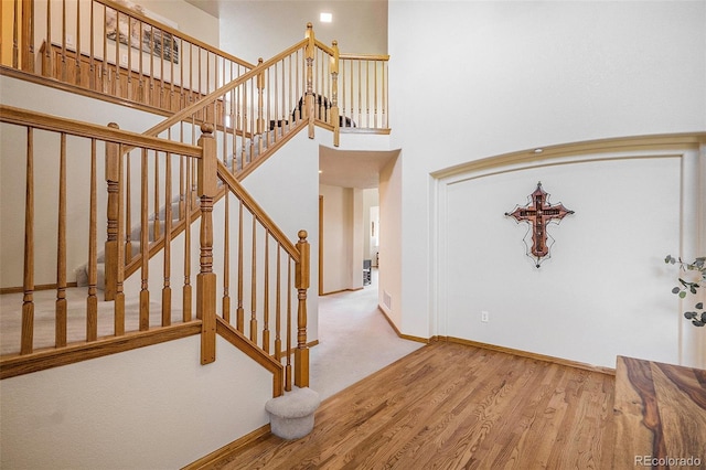 1325 Kingsfield St, Castle Rock, CO 80104 - stairway featuring wood finished floors, baseboards, and a towering ceiling