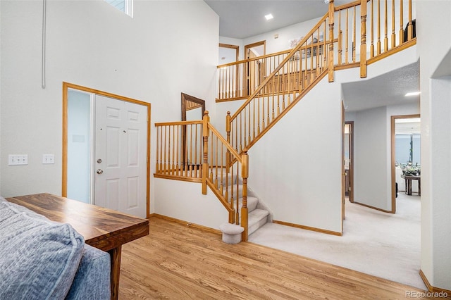1325 Kingsfield St, Castle Rock, CO 80104 - staircase with a high ceiling, wood finished floors, and baseboards