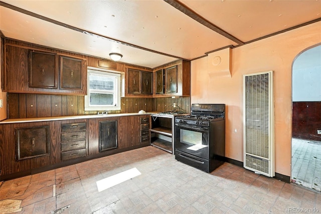 12 Marshall Pl, Longmont, CO 80504 - kitchen with black gas range, a heating unit, arched walkways, dark brown cabinets, and brick patterned floors