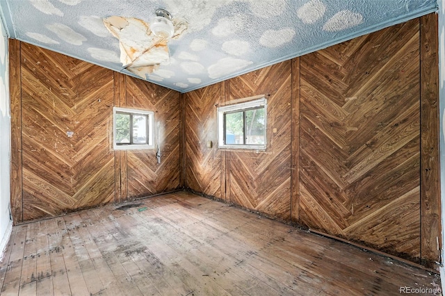 12 Marshall Pl, Longmont, CO 80504 - spare room with hardwood / wood-style flooring and wooden walls