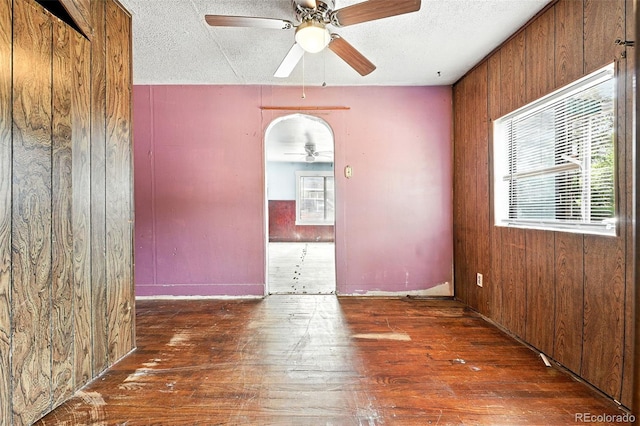 12 Marshall Pl, Longmont, CO 80504 - empty room featuring ceiling fan, wood-type flooring, wooden walls, and a textured ceiling