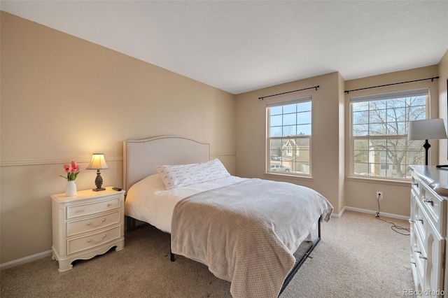 bedroom with light carpet and baseboards