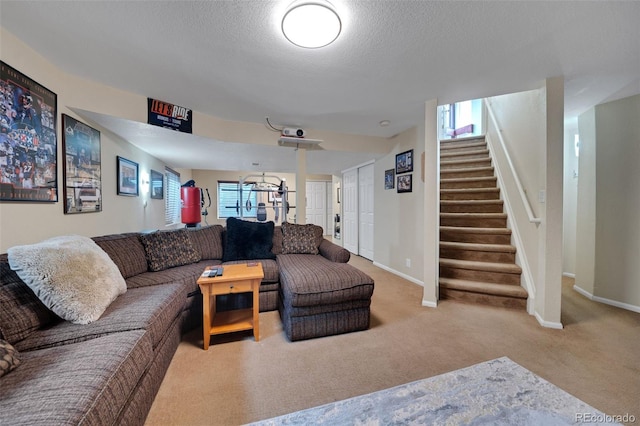 living area featuring a textured ceiling, baseboards, carpet, and stairs