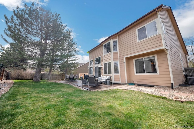 rear view of house featuring fence, a lawn, a patio, and an outdoor hangout area