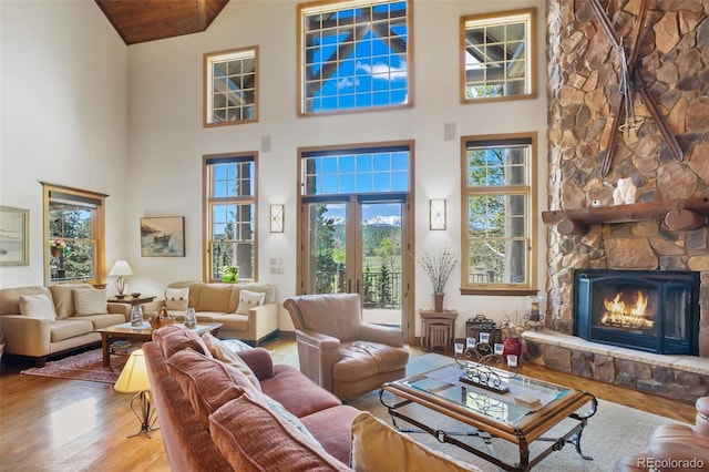 221 Columbine Pl, Woodland Park, CO 80863 - living room with wood finished floors, high vaulted ceiling, and a stone fireplace