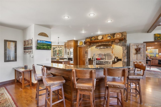 221 Columbine Pl, Woodland Park, CO 80863 - bar area featuring ventilation hood, wood finished floors, hanging light fixtures, double oven, and recessed lighting