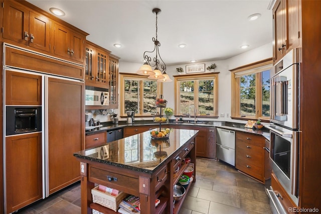 221 Columbine Pl, Woodland Park, CO 80863 - kitchen featuring appliances with stainless steel finishes, open shelves, brown cabinets, dark stone countertops, and pendant lighting