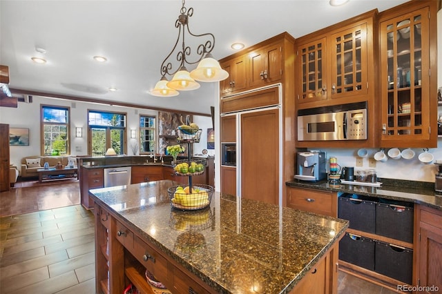 221 Columbine Pl, Woodland Park, CO 80863 - kitchen with appliances with stainless steel finishes, open floor plan, brown cabinets, a kitchen island, and recessed lighting