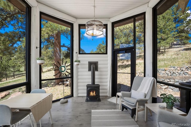 221 Columbine Pl, Woodland Park, CO 80863 - sunroom with a wood stove, wood finished floors, a chandelier, and a deck