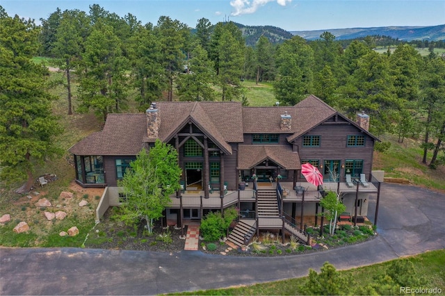 221 Columbine Pl, Woodland Park, CO 80863 - view of front of home with a chimney, stairway, a view of trees, a deck, and a shingled roof