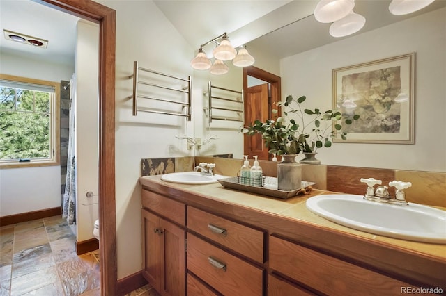 221 Columbine Pl, Woodland Park, CO 80863 - full bathroom featuring double vanity, stone tile floors, and lofted ceiling