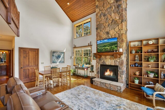 221 Columbine Pl, Woodland Park, CO 80863 - living area with wood ceiling, a stone fireplace, high vaulted ceiling, and wood finished floors