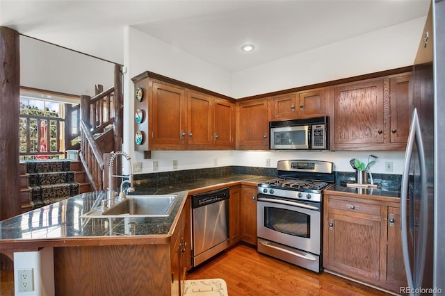 221 Columbine Pl, Woodland Park, CO 80863 - kitchen featuring stainless steel appliances, tile counters, light wood-style flooring, a peninsula, and brown cabinets