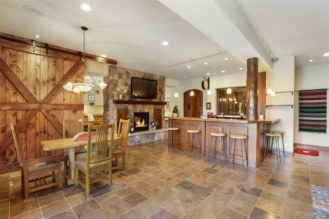 221 Columbine Pl, Woodland Park, CO 80863 - dining area with bar area, a fireplace, track lighting, recessed lighting, and stone finish flooring