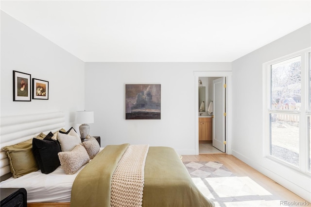 bedroom featuring baseboards and light wood finished floors