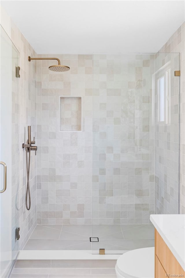 full bath featuring toilet, a shower stall, and vanity