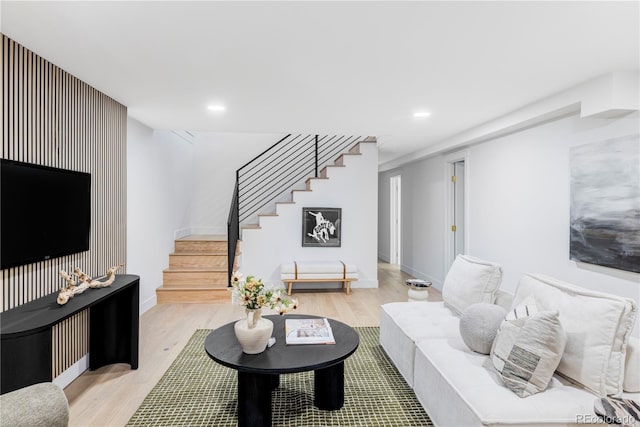 living area with recessed lighting, wood finished floors, baseboards, and stairs