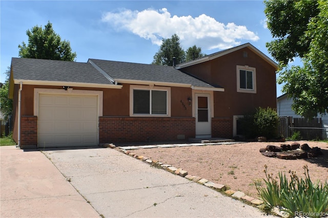 4585 Gatewood Dr, Colorado Springs, CO 80916 - split level home featuring brick siding, a garage, a shingled roof, and concrete driveway