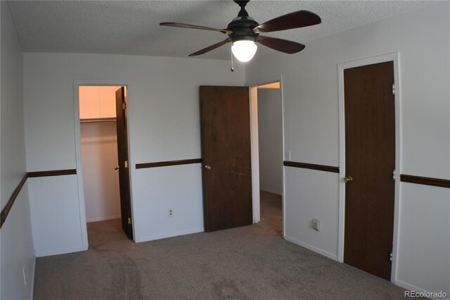 4585 Gatewood Dr, Colorado Springs, CO 80916 - unfurnished bedroom with a walk in closet, carpet, a textured ceiling, a closet, and ceiling fan