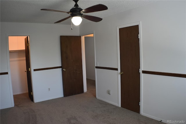 4585 Gatewood Dr, Colorado Springs, CO 80916 - unfurnished bedroom with a walk in closet, carpet, a textured ceiling, and a closet