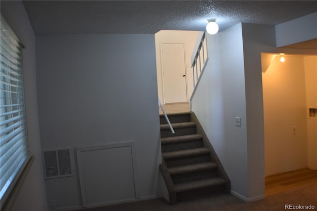 4585 Gatewood Dr, Colorado Springs, CO 80916 - staircase featuring carpet floors and a textured ceiling