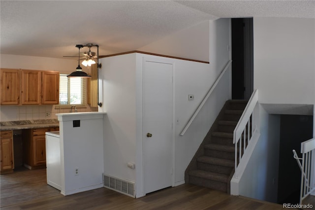 4585 Gatewood Dr, Colorado Springs, CO 80916 - kitchen featuring wood finished floors, a ceiling fan, a textured ceiling, light countertops, and brown cabinetry