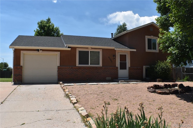 4585 Gatewood Dr, Colorado Springs, CO 80916 - split level home featuring brick siding, a garage, driveway, a shingled roof, and stucco siding