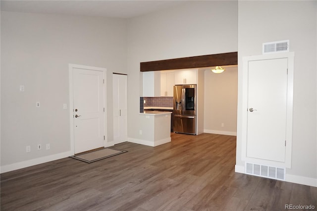 12033 E Harvard Ave Unit 208, Aurora, CO 80014 - kitchen featuring stainless steel fridge, white cabinets, decorative backsplash, light countertops, and wood finished floors